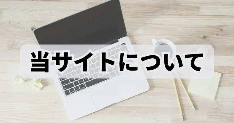 木製テーブルの上に置かれたノートパソコンとコーヒーと筆記用具の写真