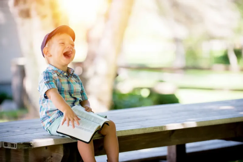 ベンチに座って笑っている子どもの写真