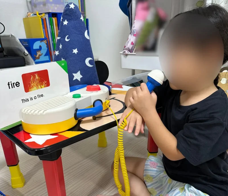 女の子がマイクを持って英単語カードをリピートしている写真