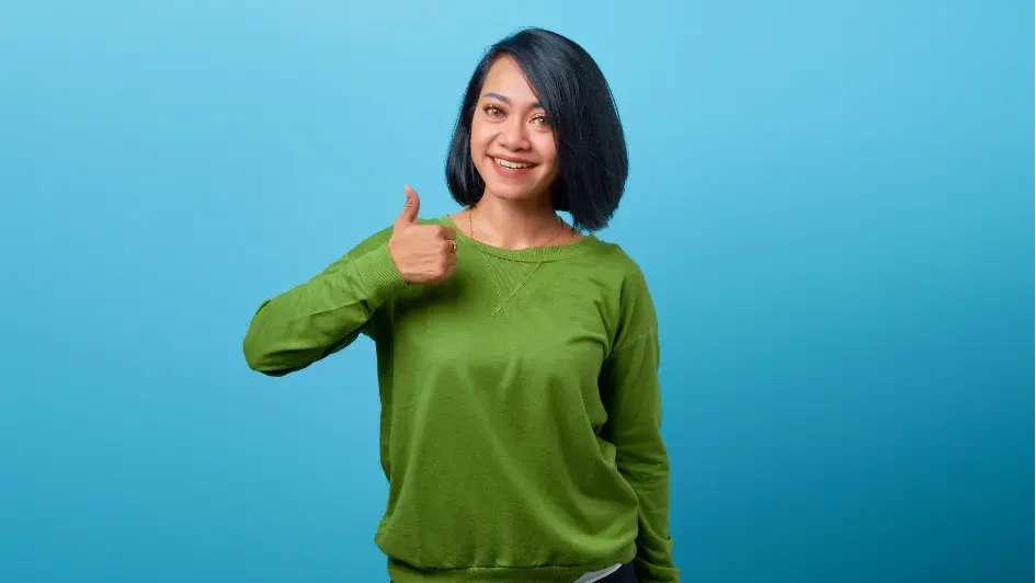 笑顔でサムズアップする女性の写真