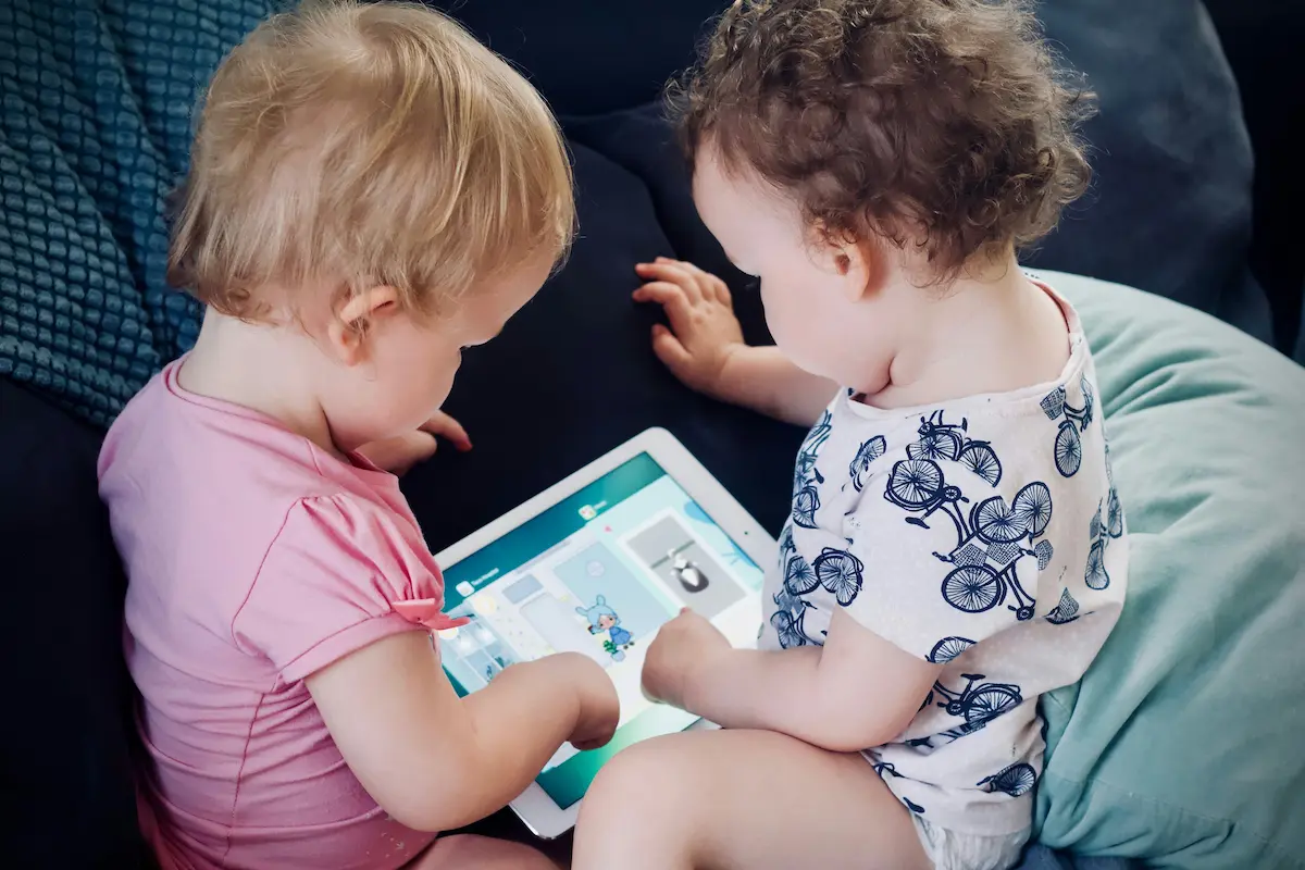 タブレットをのぞき込む2人の幼児の写真