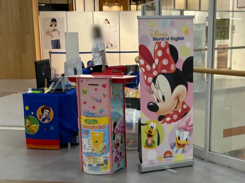 ディズニーキャラクターの看板とディズニーグッズを紹介する街角のブース