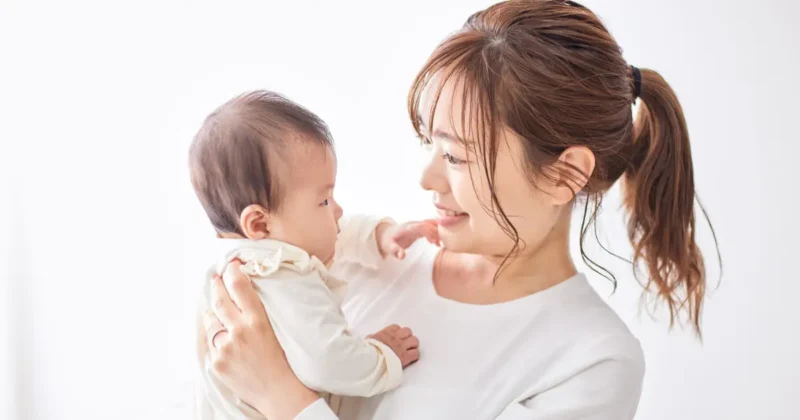 赤ちゃんを抱っこして微笑んでいるママ