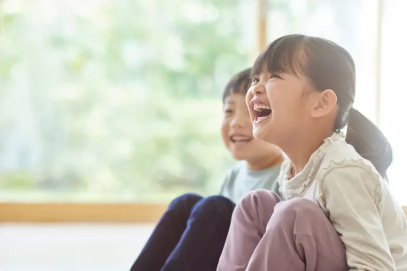 床に座って笑う男の子と女の子